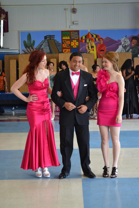 two female students in dresses with one male student in a suit